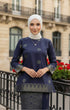 Woman wearing a Kurung Kedah Blue Black Gold showing songket woven design and fit in an urban setting