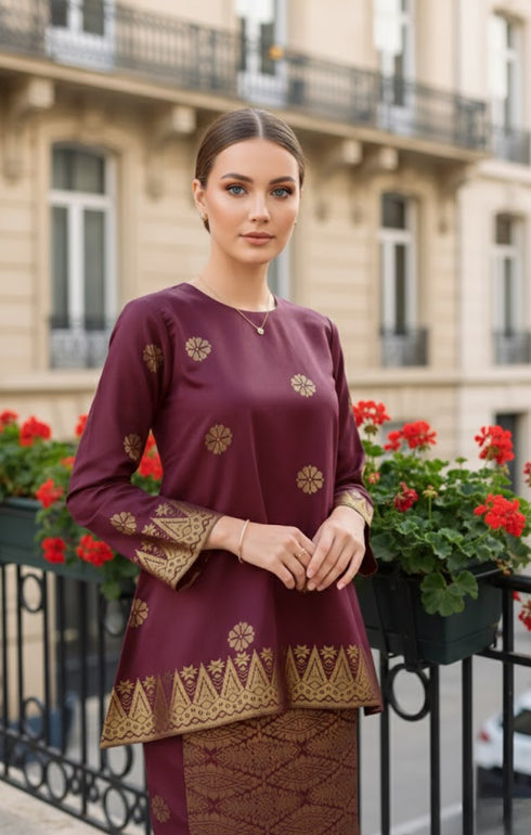Woman wearing a Kurung Kedah Dark Maroon Gold showing songket woven design and regular fit traditional outfit in an urban setting.