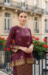 Woman wearing a Kurung Kedah Dark Maroon Gold showing songket woven design and regular fit traditional outfit in an urban setting.