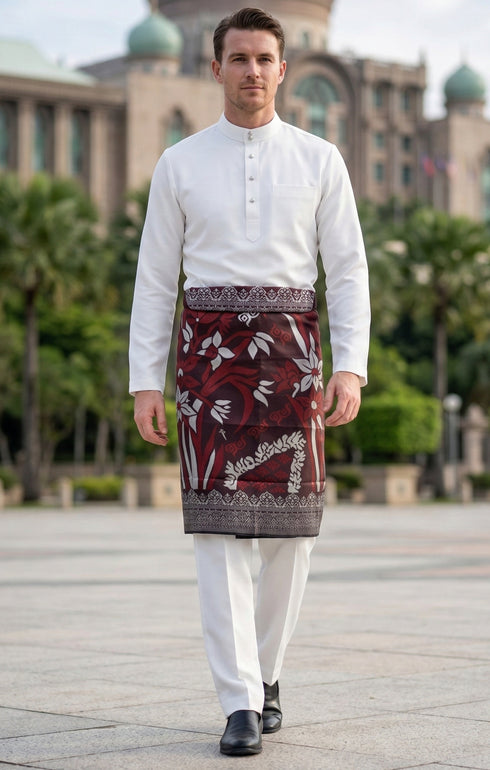 Man wearing a traditional outfit Premium burgundy instant sampin tanjung with elegant traditional Malay design outdoor setting.