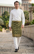 Man wearing a Sampin Instant Kasturi traditional Olive green Gold outdoor background in an outdoor setting.