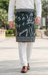 Man wearing a traditional outfit Sampin Instant Tanjung Emerald Silver in an outdoor setting, and brown shoes outdoors.