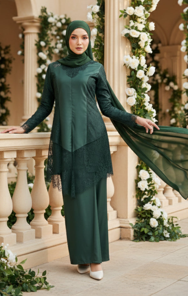 Woman in a Kebaya Moden Emerald Green front view on model showing V-neck and lace details standing on a balcony with floral decorations