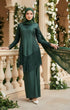 Woman in a Kebaya Moden Emerald Green front view on model showing V-neck and lace details standing on a balcony with floral decorations