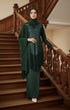 Woman in a Kebaya Moden Emerald Green model highlighting long sleeve fit standing on wooden stairs with decorative railings.