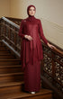 Woman in a Kebaya Moden Maroon dress standing on a staircase