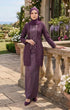 Woman wearing kebaya Kutu Baru Dusty Magenta front view showing V‑neck collar and French lace detailing standing outdoors with floral decorations.