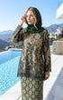 model wearing Kurung Kedah Lace Songket Emerald Green close-up French lace and songket texture by a pool with mountains in the background