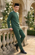 Man in Baju Melayu Teluk Belanga Emerald Green side view showing regular fit standing on a stone balcony with floral decorations
