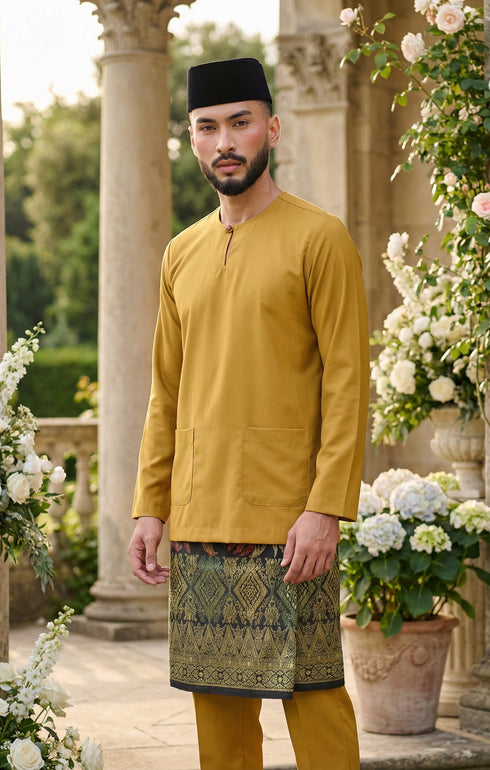 Man wearing Baju Melayu Teluk Belanga Mustard traditional attire with a sampin 3d, outdoor setting with flowers and columns.