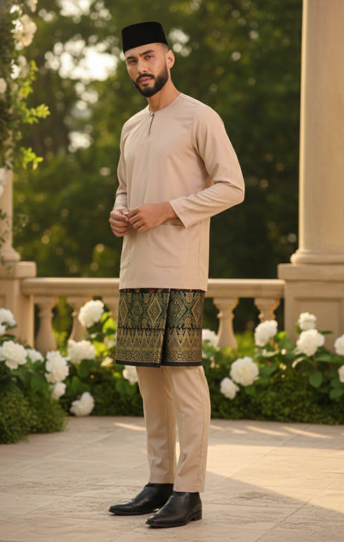 Man in traditional attire Baju Melayu Teluk Belanga Nude standing outdoors with greenery and flowers in the background