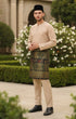 Baju Melayu Teluk Belanga Nude traditional attire side view showing sleeve and fit in an outdoor setting