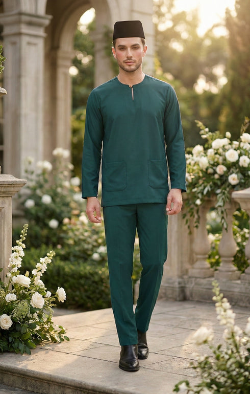 Man in Baju melayu Teal green traditional outfit standing in a garden with floral decorations