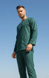Man wearing a Baju melayu Teal green scrub set against a clear blue sky