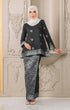 Model wearing Aryana Kurung Kedah Black Silver displaying overall styling and drape with a instant hijab against an ornate wall.