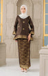 Woman wearing a Kurung Kedah Dark Rich Brown Gold traditional outfit with a matching Instant Shawl in an elegant interior setting.