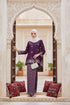Woman in a Kurung Kedah Magenta Silver outfit standing in an ornate archway with decorative cushions.