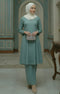 Woman in Kebarung Klasik Plain Sage Green standing in an elegant room with decorative walls and a table.