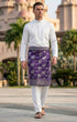 Person wearing Sampin Instant Raya Tenun Purple Silver with Baju Melayu traditional outfit front view showing full woven pattern with floral patterns outdoors.
