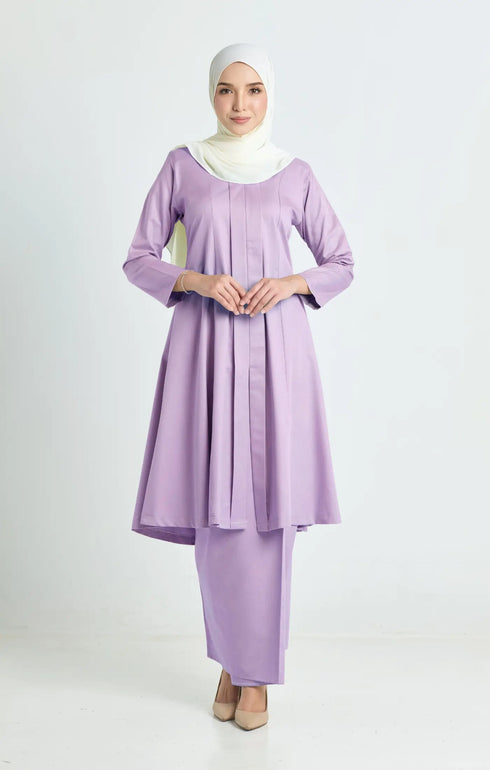 Woman wearing a Kebarung Klasik Dusty Purple showing klasik labuh design and cotton plain dress and pearl white instant shawl hijab on a white background