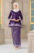 Woman wearing a Kurung Kedah Magenta Silver with a matching Instant hijab in an elegant interior setting.
