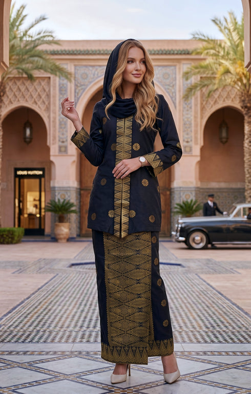 Woman in traditional Kebaya Songket Black Gold outfit standing in a courtyard with architectural elements and a car in the background.