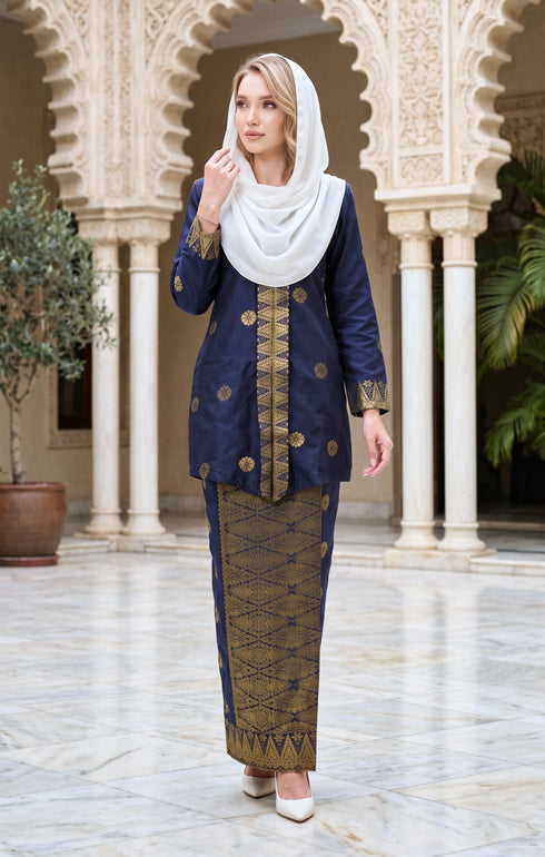 woman wearing Kebaya Kurung Moden Songket Blue Black Gold standing in a decorative architectural setting