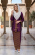Woman in traditional Kebaya Kurung Moden Songket Dark Magenta Gold in a historical building setting