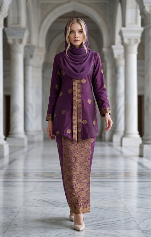 Woman in a Songket Dark Magenta Gold traditional outfit in an elegant hallway