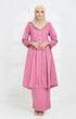 A woman wearing a traditional Kurung Kebaya Pink showing plain cotton design and standard fit with long sleeves and a V-neck collar.